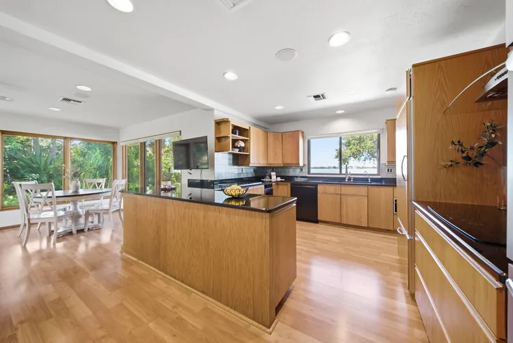 Kitchen with island, breakfast area and Banana River visible through the windows